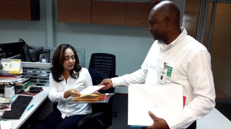 Zacarías mientras entrega la mensajería a una empleada.