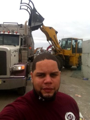 Ofelio frente a dos maquinarias pesadas.